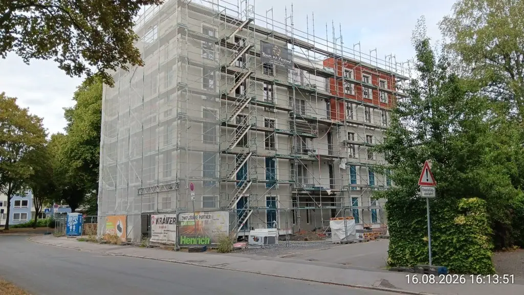 Eingerüstetes Wohngebäude der Lanstroper Wohnhöfe mit verputzter Fassade und rotem Verblendmauerwerk